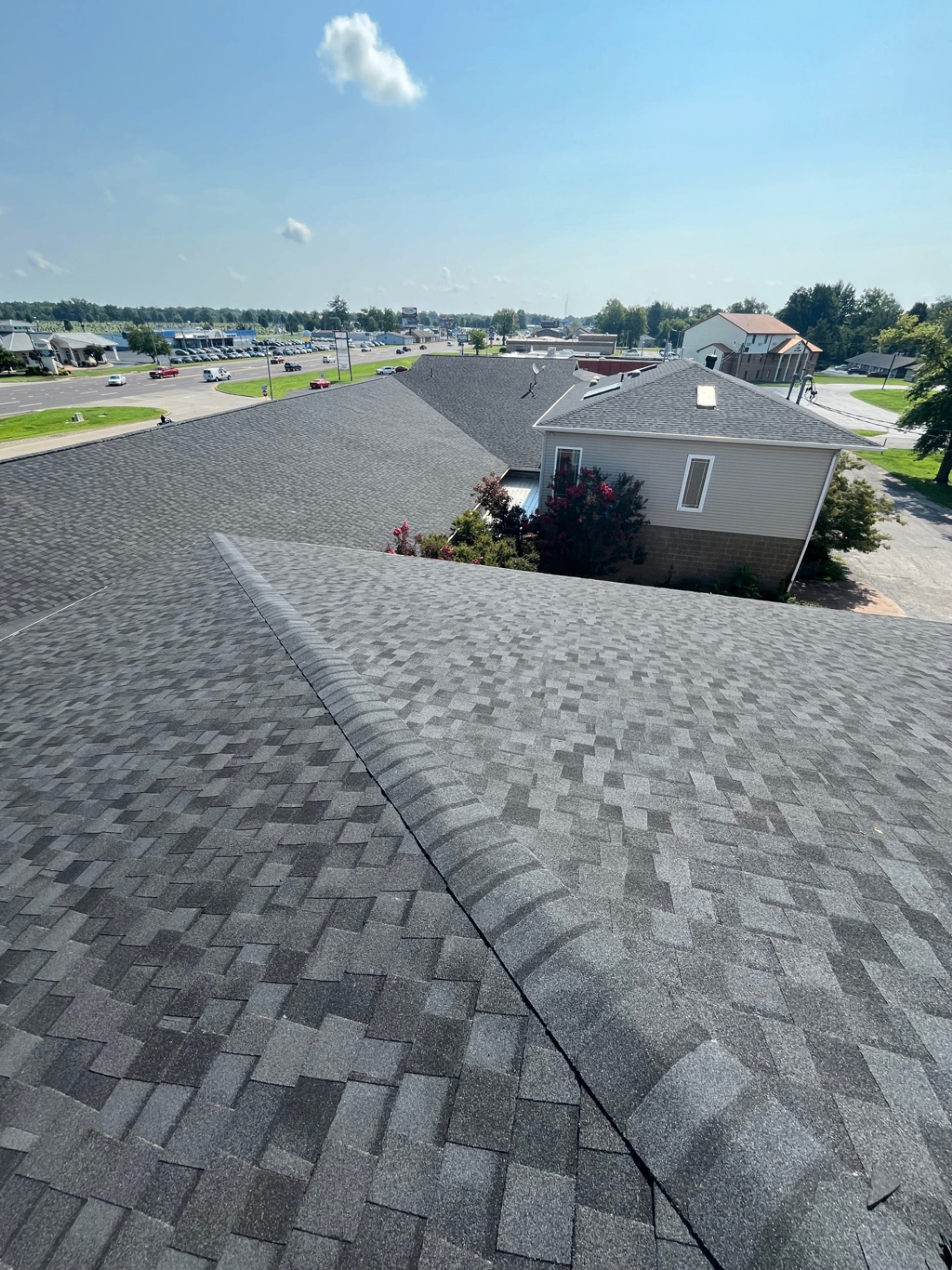 Commercial shingle roof installation overlooking a busy road in Marion, Illinois